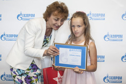 Божена Алехина получает награду из рук председателя Объединенной профсоюзной организации ДОАО «Центрэнергогаз» Ирины Карповой
